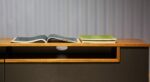 نمایی از میز تلویزیون هومان که روی آن کتاب است.